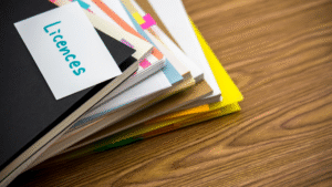 A stack of organized business documents and folders with a label reading 'Licences,' representing business licence paperwork in Indonesia.