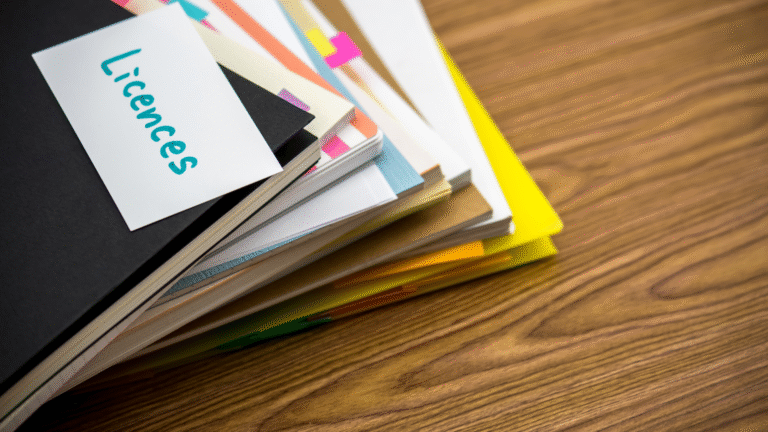 A stack of organized business documents and folders with a label reading 'Licences,' representing business licence paperwork in Indonesia.