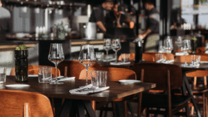 Elegant dining setup in a modern Bali restaurant with wine glasses and wooden chairs, showcasing a stylish interior ambiance.