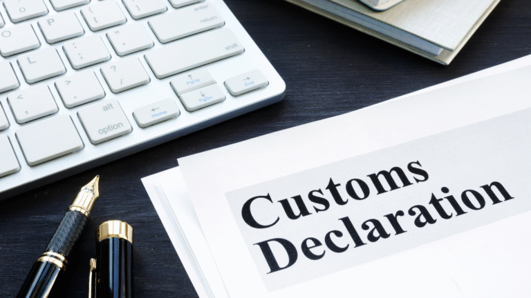 A printed customs declaration document placed on a dark desk beside a fountain pen, a white computer keyboard, and notebooks, representing the preparation process for submitting an Indonesia Customs Declaration.