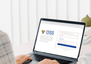 Indonesian business registration process illustrated by a person accessing the OSS (Online Single Submission) website on a laptop.