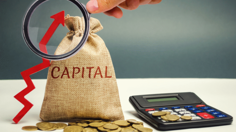 A hand holds a magnifying glass over a money bag labeled "CAPITAL" and a rising red arrow, with scattered coins and a calculator symbolizing increasing financial resources and investment, a crucial aspect for the success and expansion of a PT PMA.