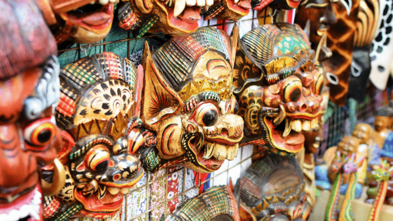 Colorful traditional Balinese masks displayed at a market stall, showcasing the intricate craftsmanship of the Bali handicraft business.