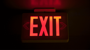 A glowing red EXIT sign symbolizing the importance of following proper procedures for leaving Indonesia for expats.