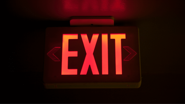 A glowing red EXIT sign symbolizing the importance of following proper procedures for leaving Indonesia for expats.