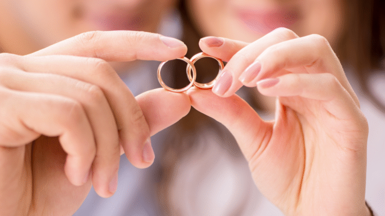 A close-up of a couple holding wedding rings together, symbolizing commitment and unity, relevant to registering foreign marriage in Indonesia.