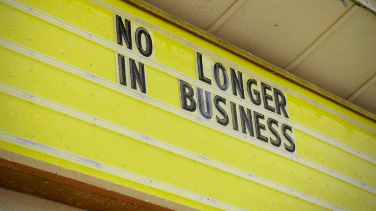 Yellow signboard with bold black letters reading “No Longer in Business,” representing the process to dissolve a company.