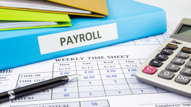 Payroll outsourcing in Indonesia concept with payroll binder, timesheet, calculator, and pen on desk.