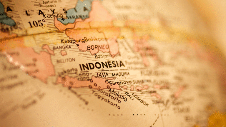 Close-up of a vintage map showing Indonesia’s islands and cities, illustrating why people move to Indonesia for its location.