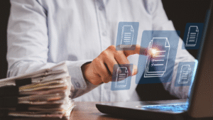 Businessman using a laptop with digital document icons, representing the OSS System in Indonesia for online business licensing.