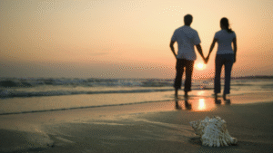 A couple holding hands while walking along a Bali beach at sunset, symbolizing the peaceful long-term lifestyle offered by the second home visa Indonesia program.